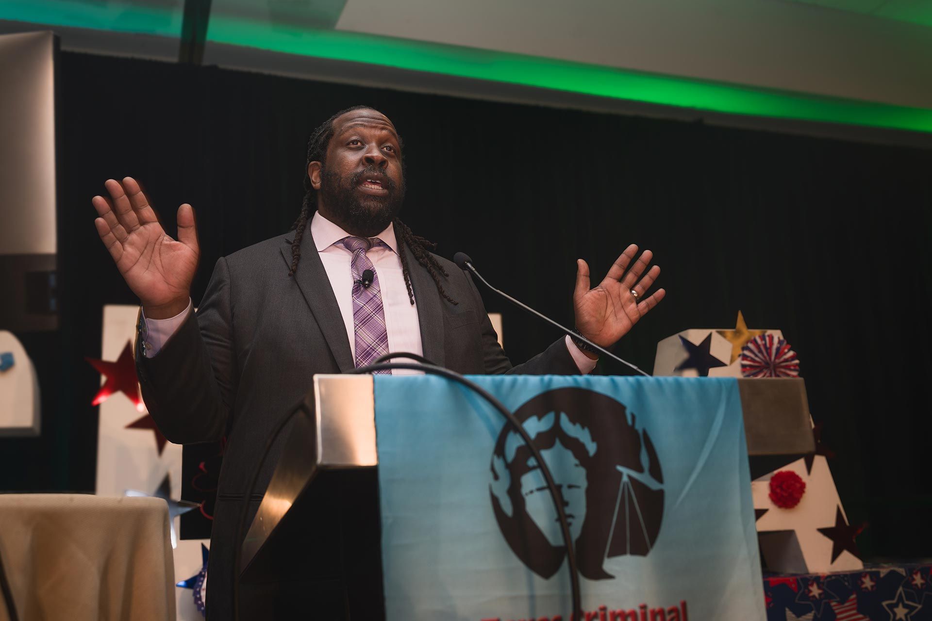 Man in suit speaking on stage with