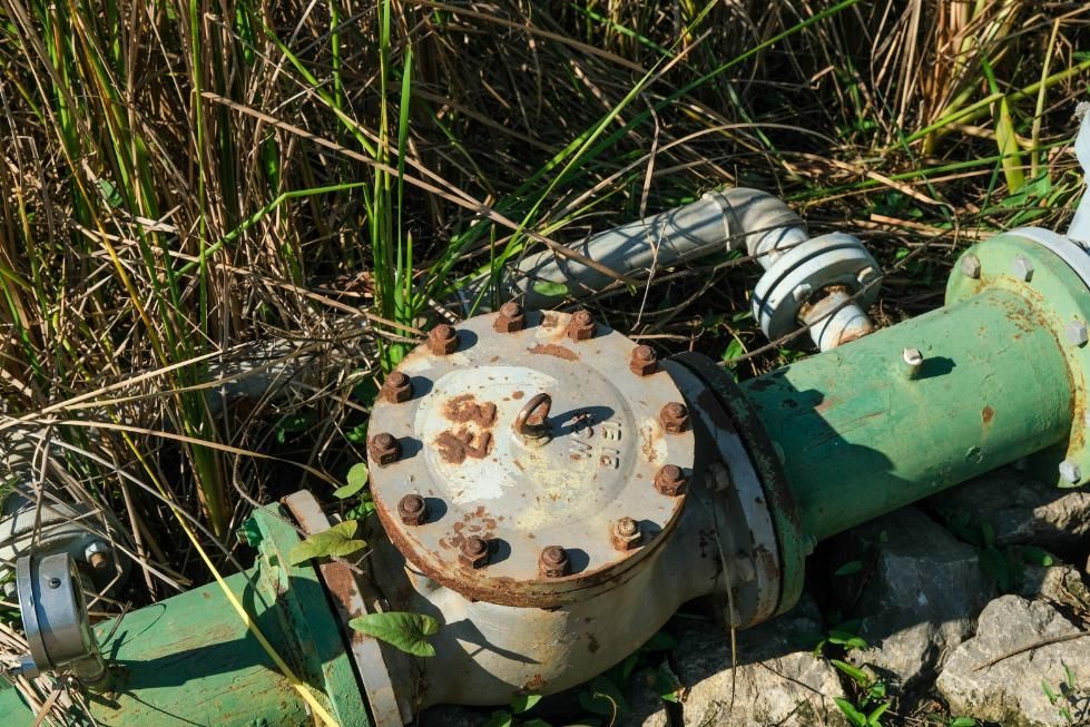 A Close Up Of A Green Pipe With A Valve On It In The Grass — Liquid Waste Disposal in Port Macquarie, NSW