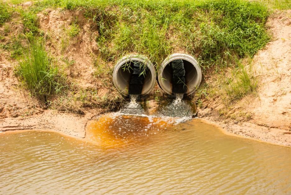 Two Pipes Are Draining Water Into A Body Of Water — Liquid Waste Disposal in Lake Cathie, NSW