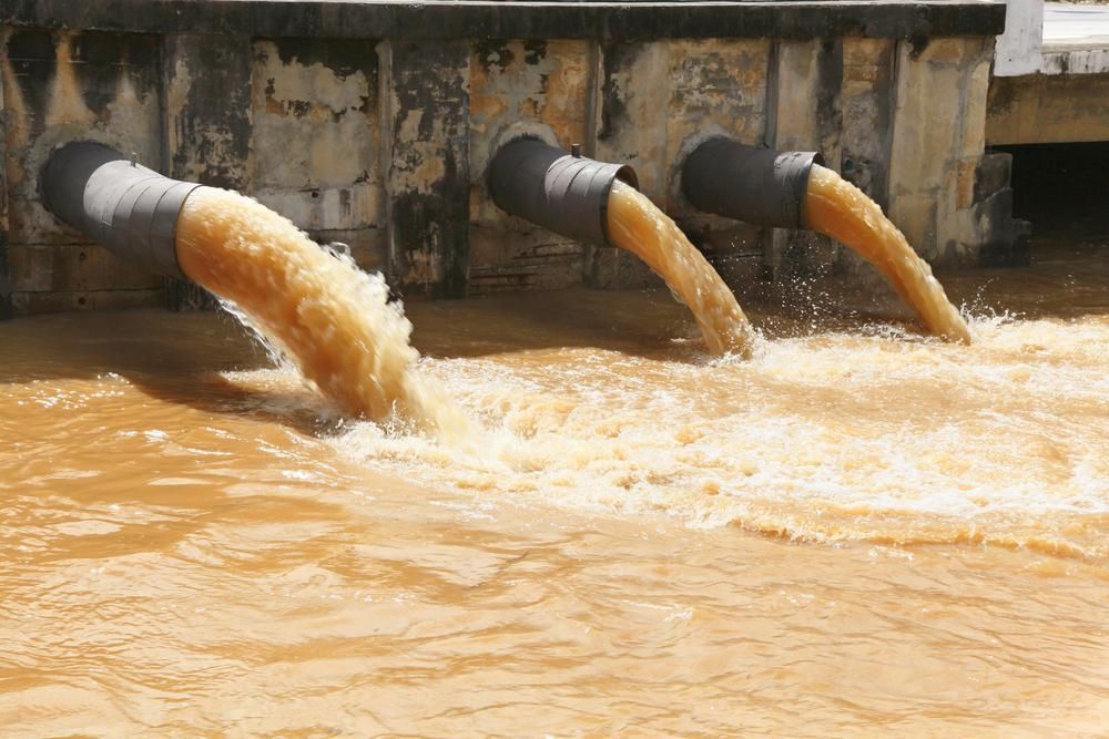 Three Pipes Are Pouring Brown Water Into A Body Of Water — Liquid Waste Disposal in Lake Cathie, NSW