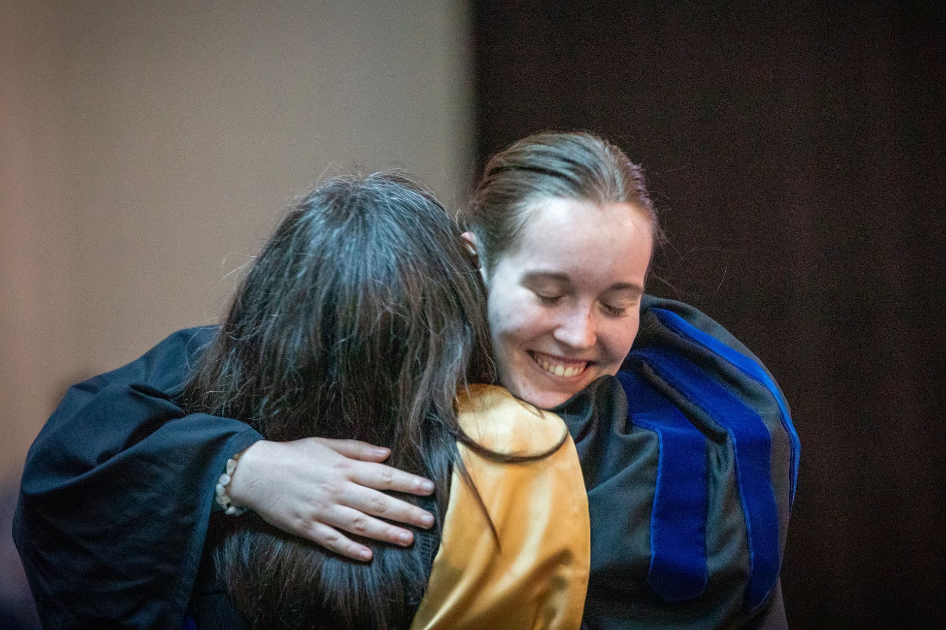 Two people hugging warmly indoors