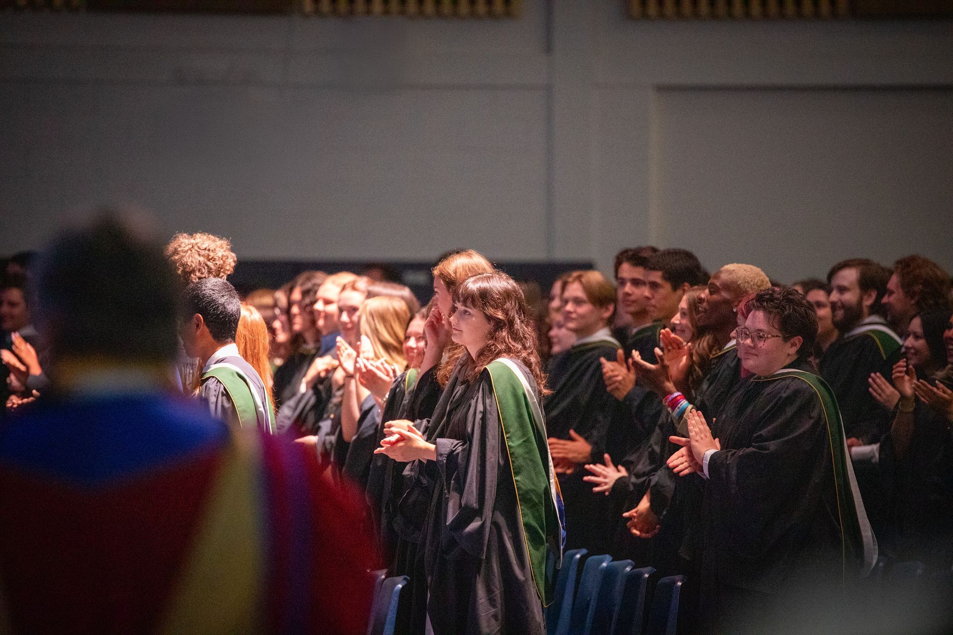 Graduates standing and applauding 