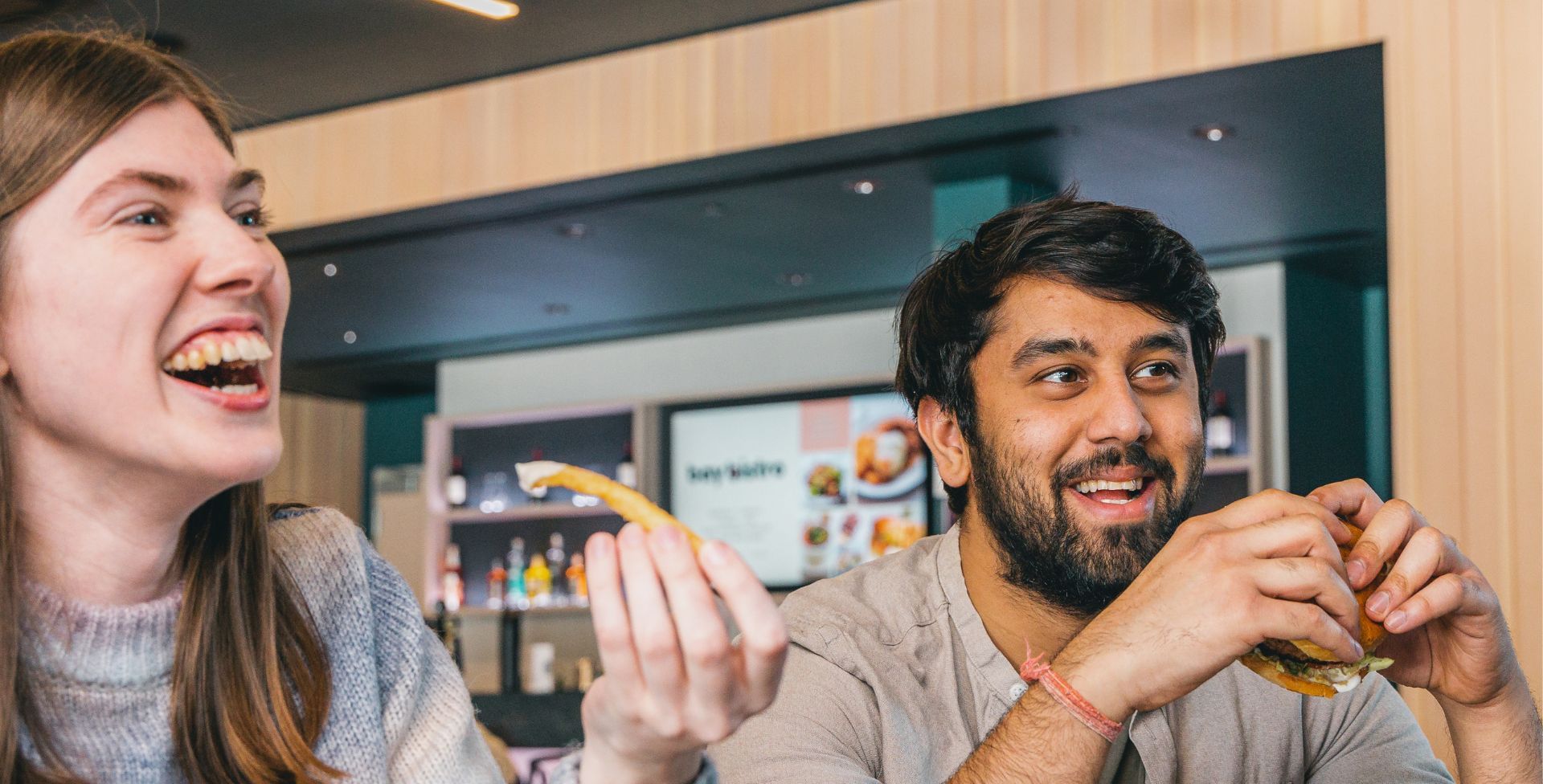 Two people laughing at a café counter