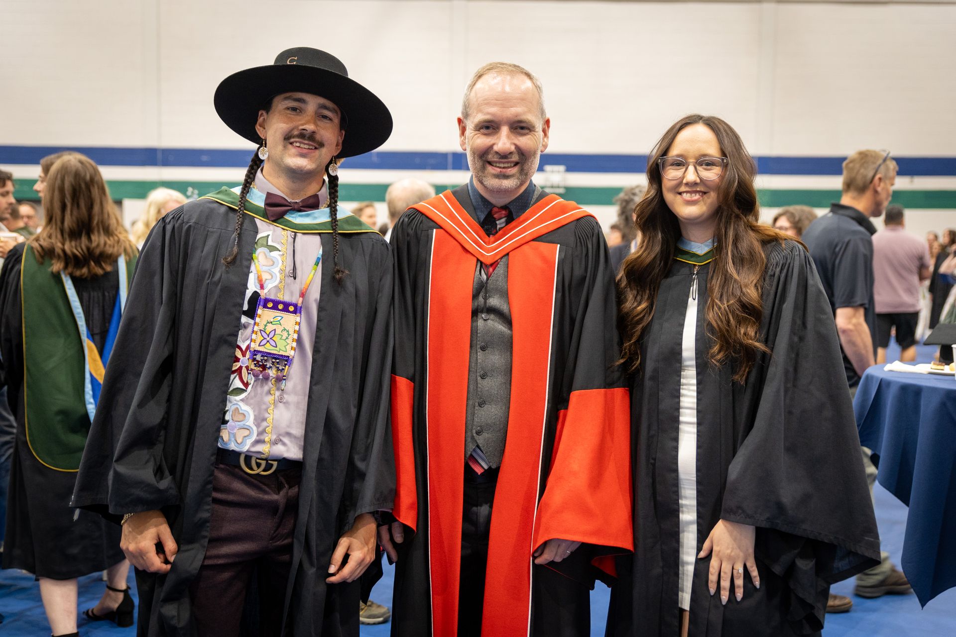 Two Nipissing University graduates with faculty member