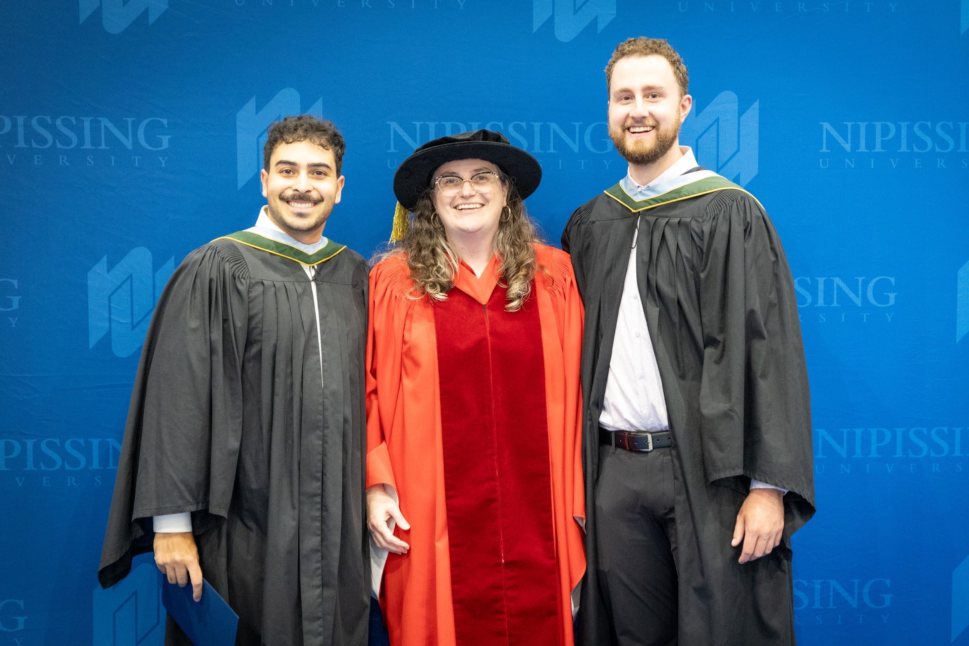 Two Nipissing University graduates with faculty member