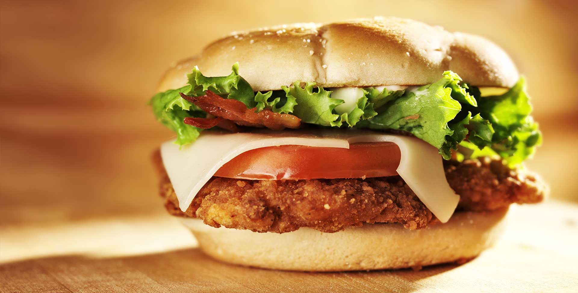 Sesame seed burger with lettuce, tomato, cheese, and patty on a bun