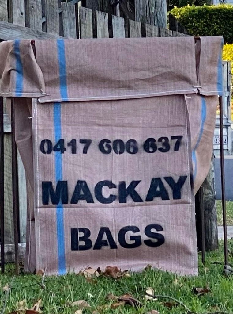 A blue trash can filled with plants is sitting next to a bunch of plants — Mackay Bags in East Mackay, QLD