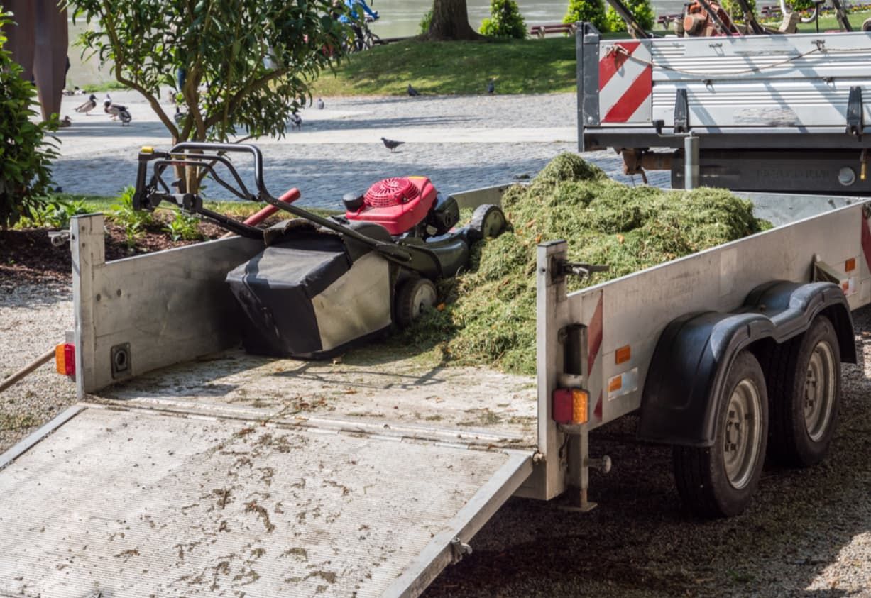 A Trailer With A Lawn Mower On It Is Parked Next To A Truck — Mackay Bags in Walkerston, QLD