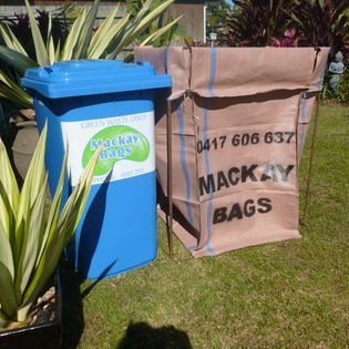 A Blue Bin and Tan Garden Bag Sitting on a Lawn — Mackay Bags in East Mackay, QLD