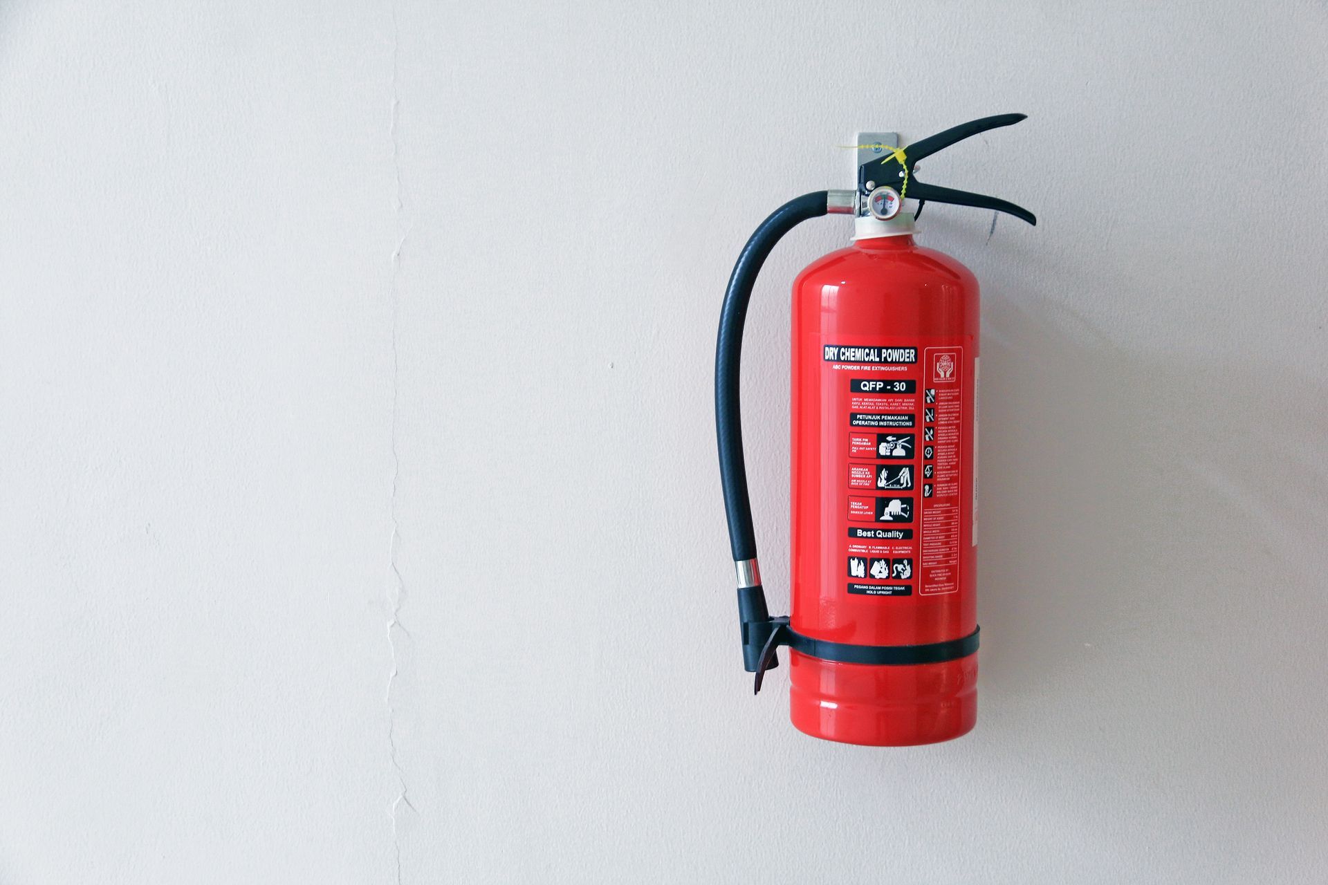 A fire extinguisher mounted on the wall A fire extinguisher mounted on the wall