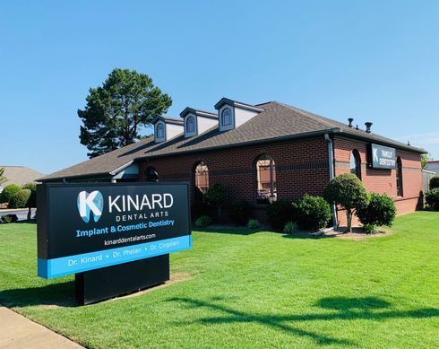 A dental office with a sign in front of it