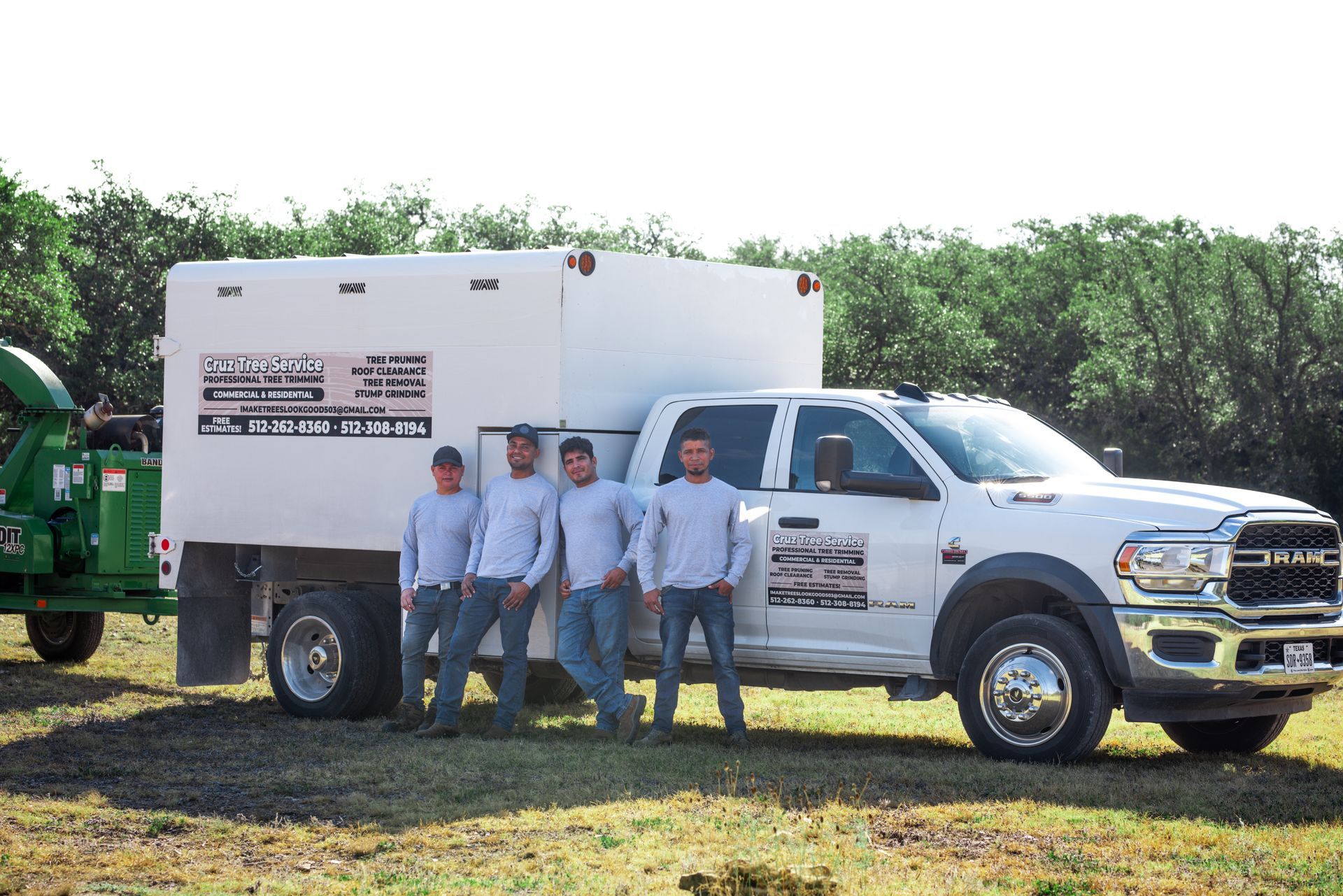 A group of men are standing in front of a white truck.