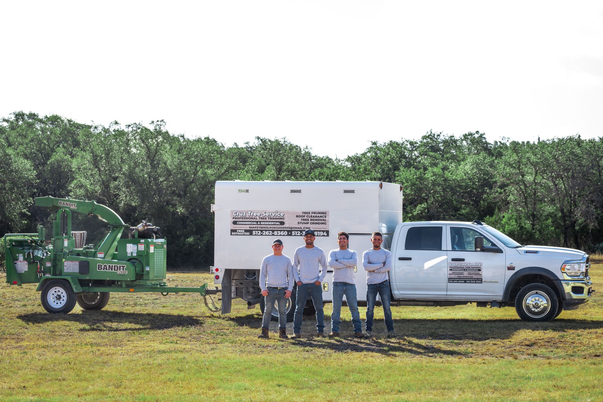 A group of men standing in front of a truck and trailer