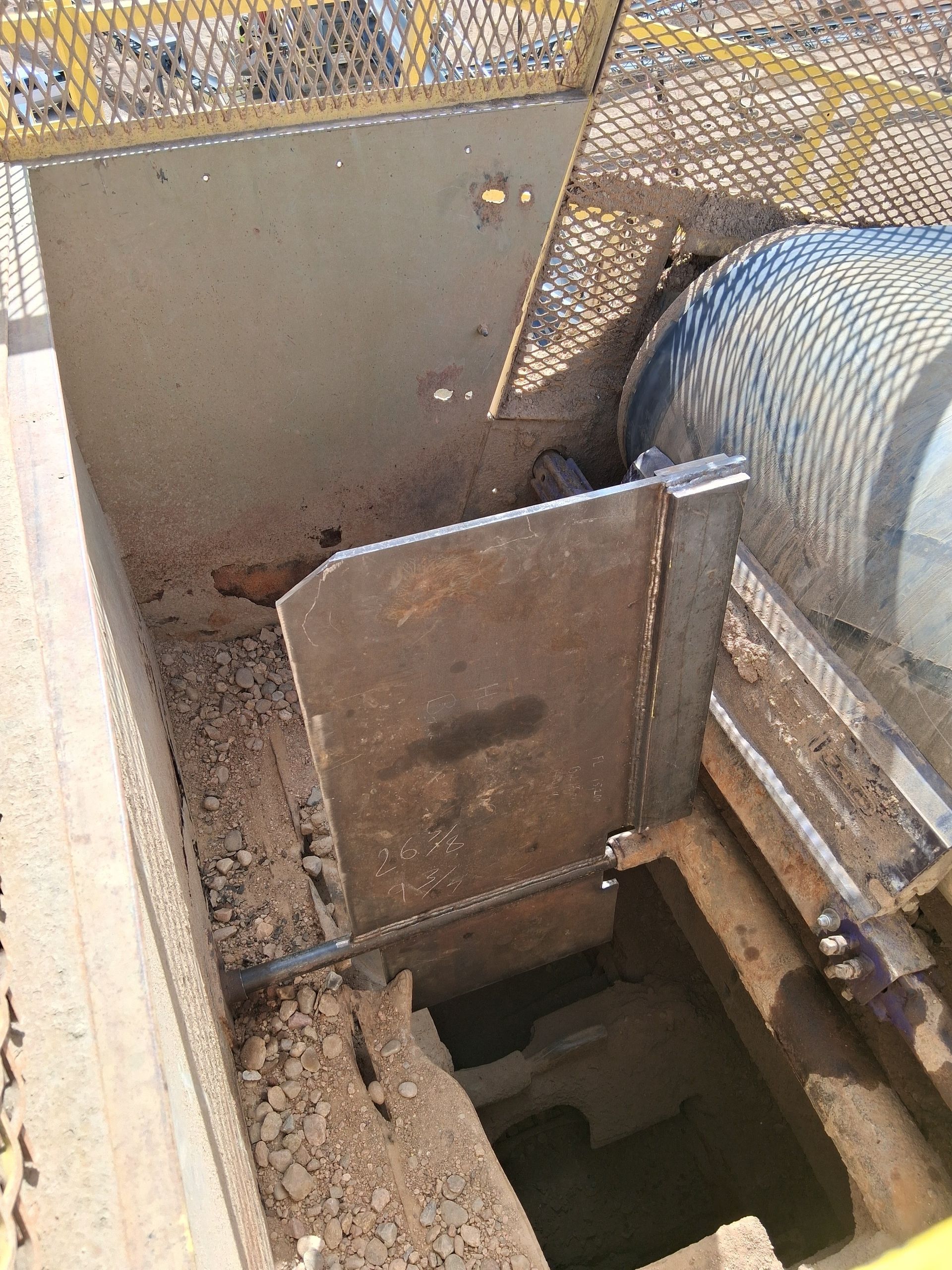 Close-up of a trailer corner with red reflector, metal welds, and mesh ramp deck on pavement