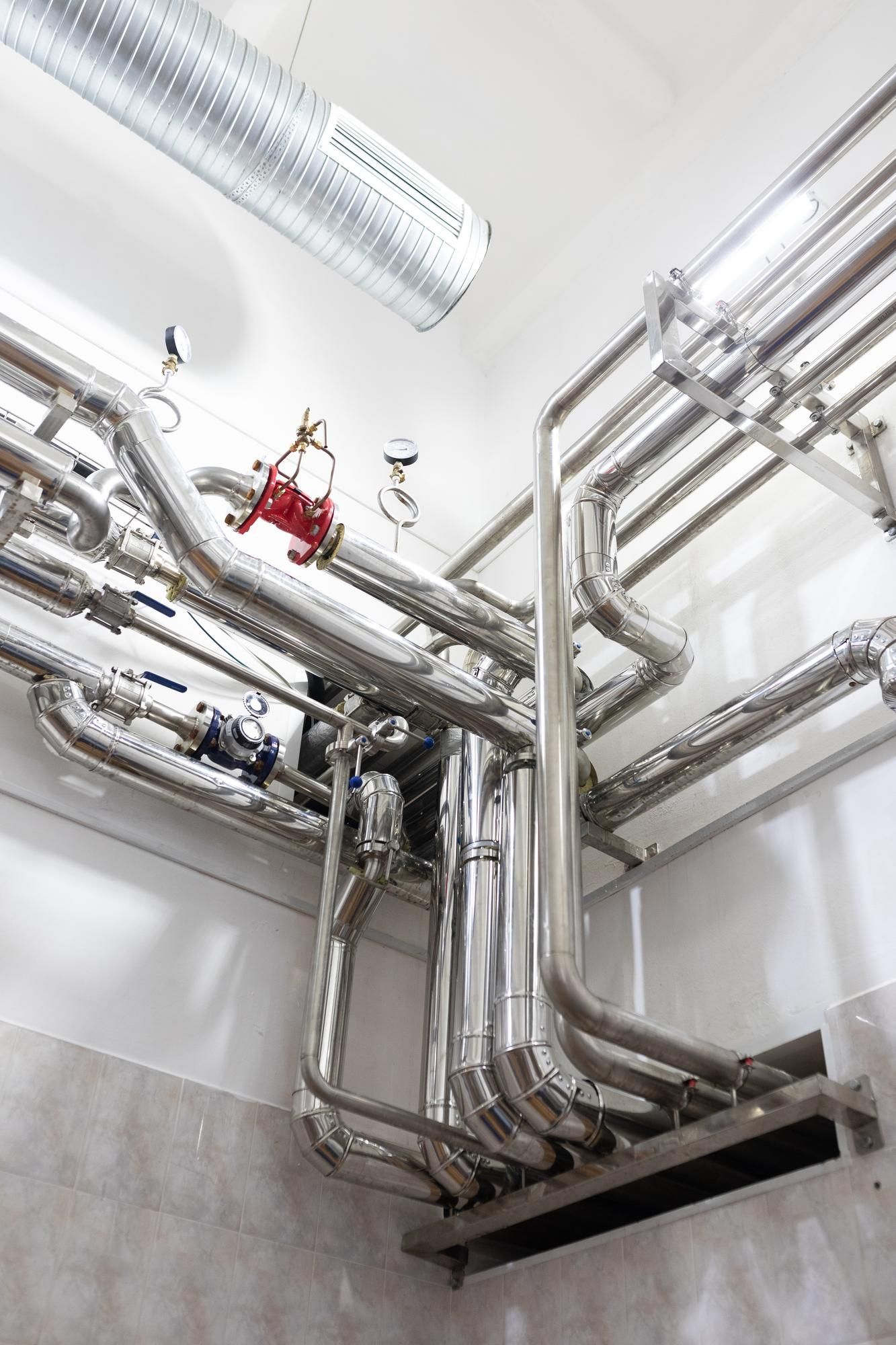 A bunch of pipes are hanging from the ceiling in a room.