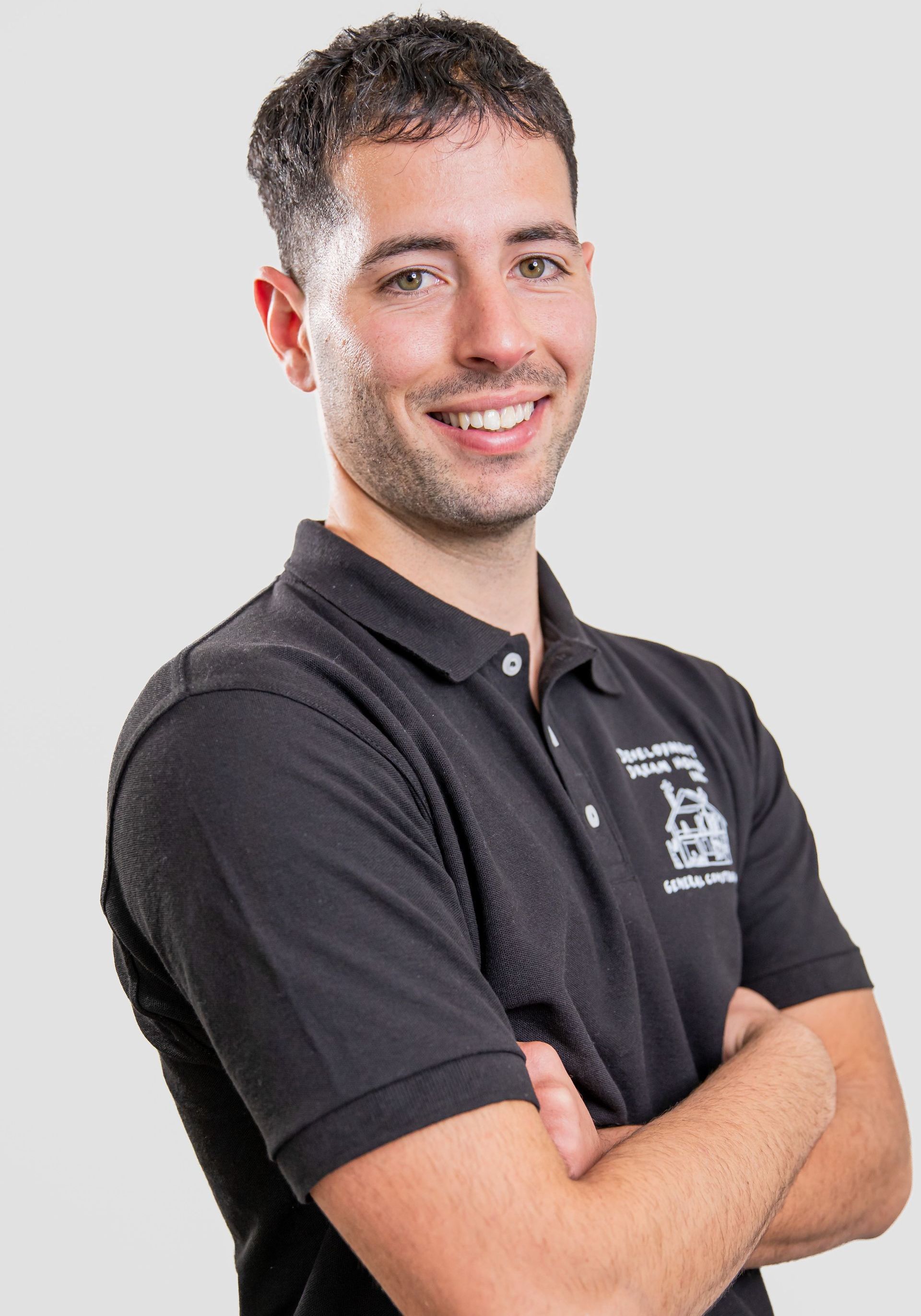A man is wearing a black polo shirt with an american flag on the sleeve.