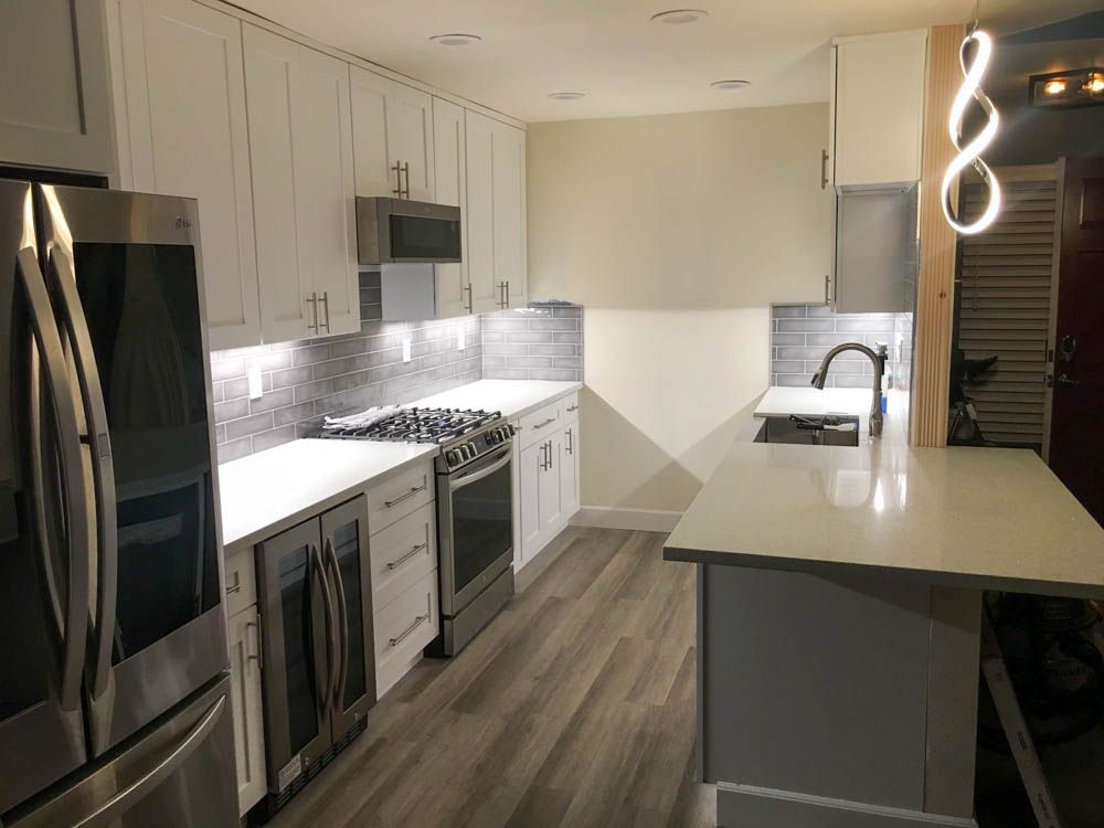 A kitchen with white cabinets and stainless steel appliances