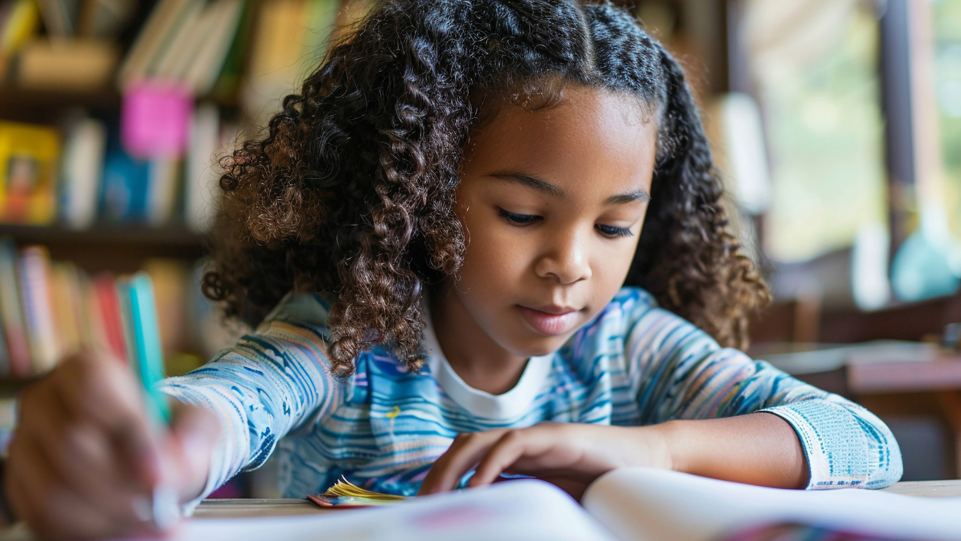 Child writing in a notebook at a desk, focused in a classroom or library setting.