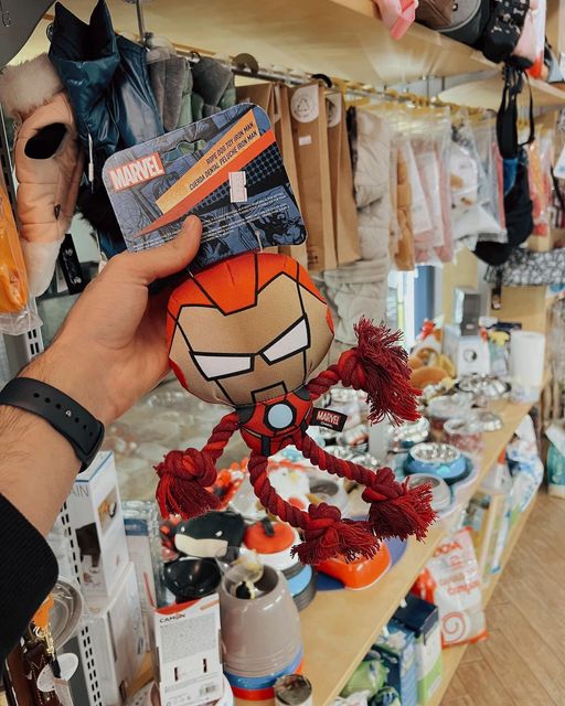 Mano che tiene un peluche di Spider-Man rosso e nero nella corsia di un negozio di articoli da regalo