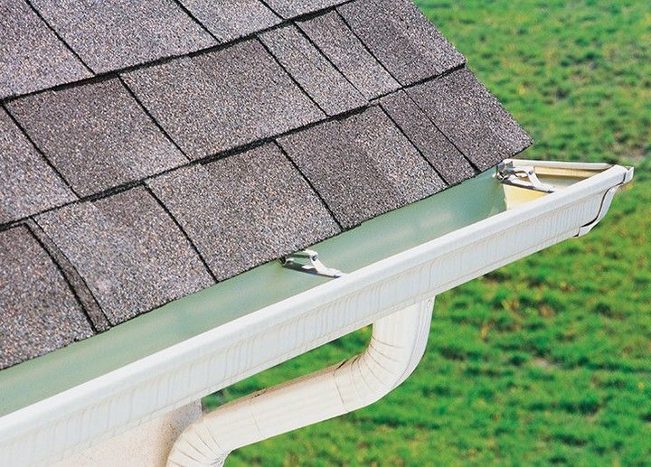 Gray shingle roof with a light green gutter, against a green background.