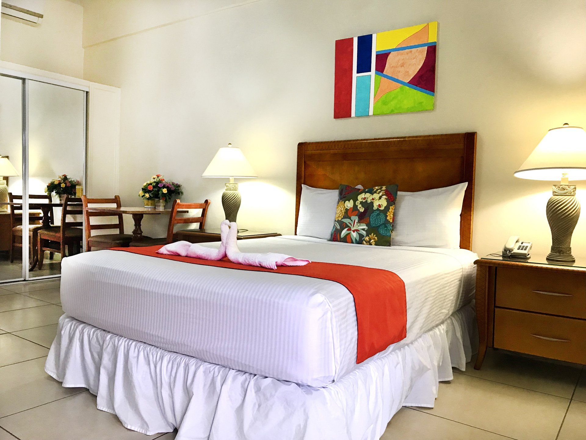 A hotel room with a king size bed and two lamps
