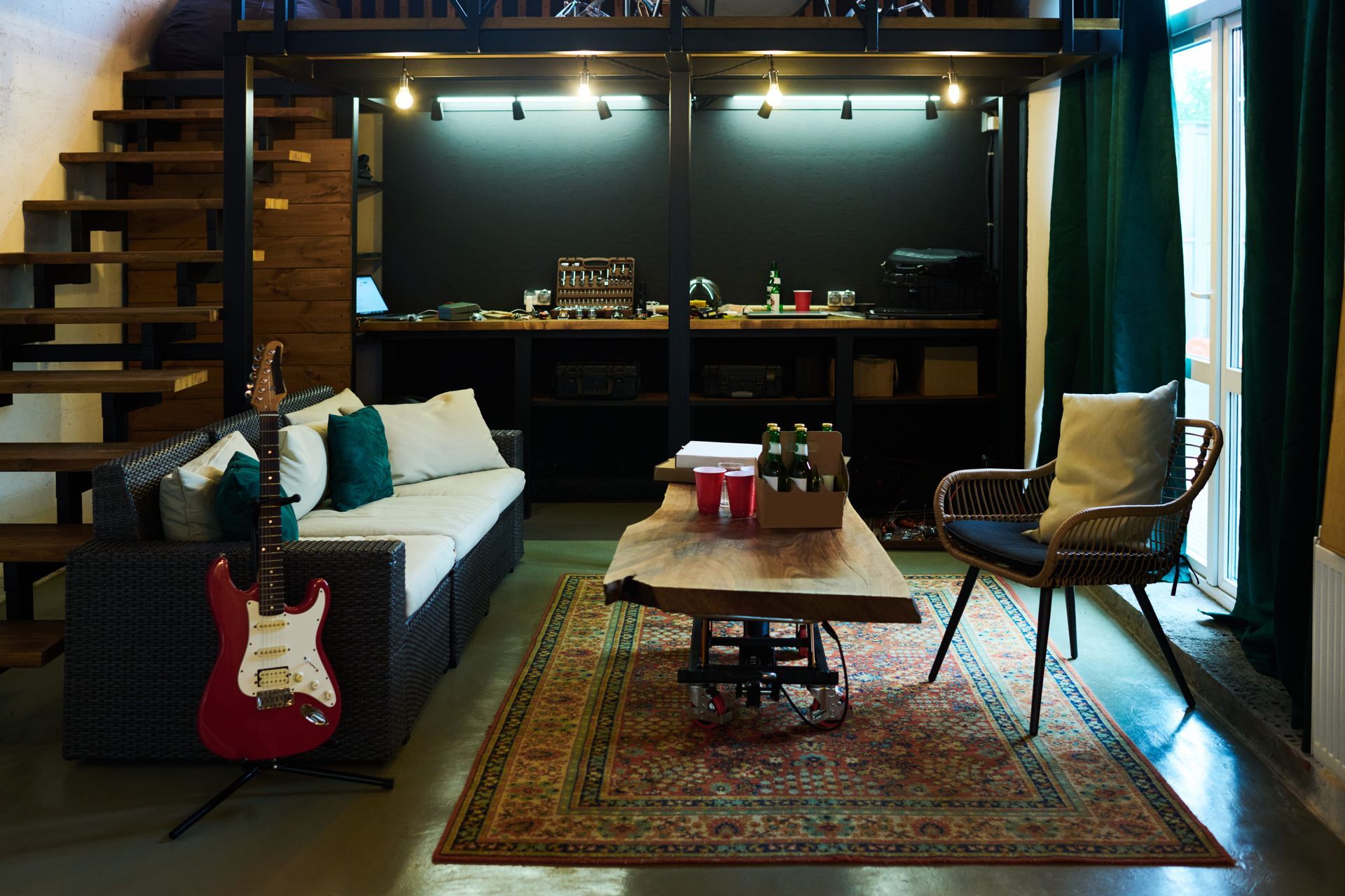 Living room with sofa, guitar, rug, wooden table, and loft with desk and shelves.
