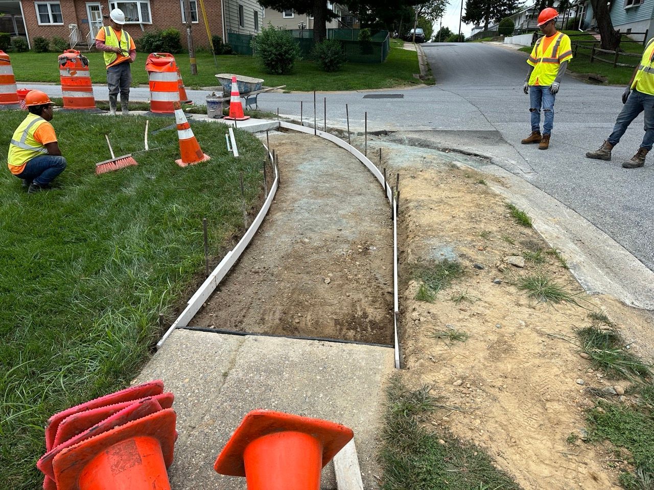 a group of construction workers are working on a sidewalk .