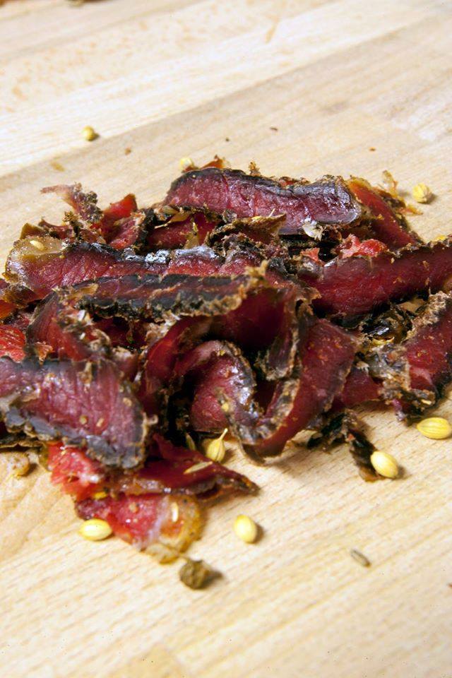 A pile of meat is on a wooden cutting board.