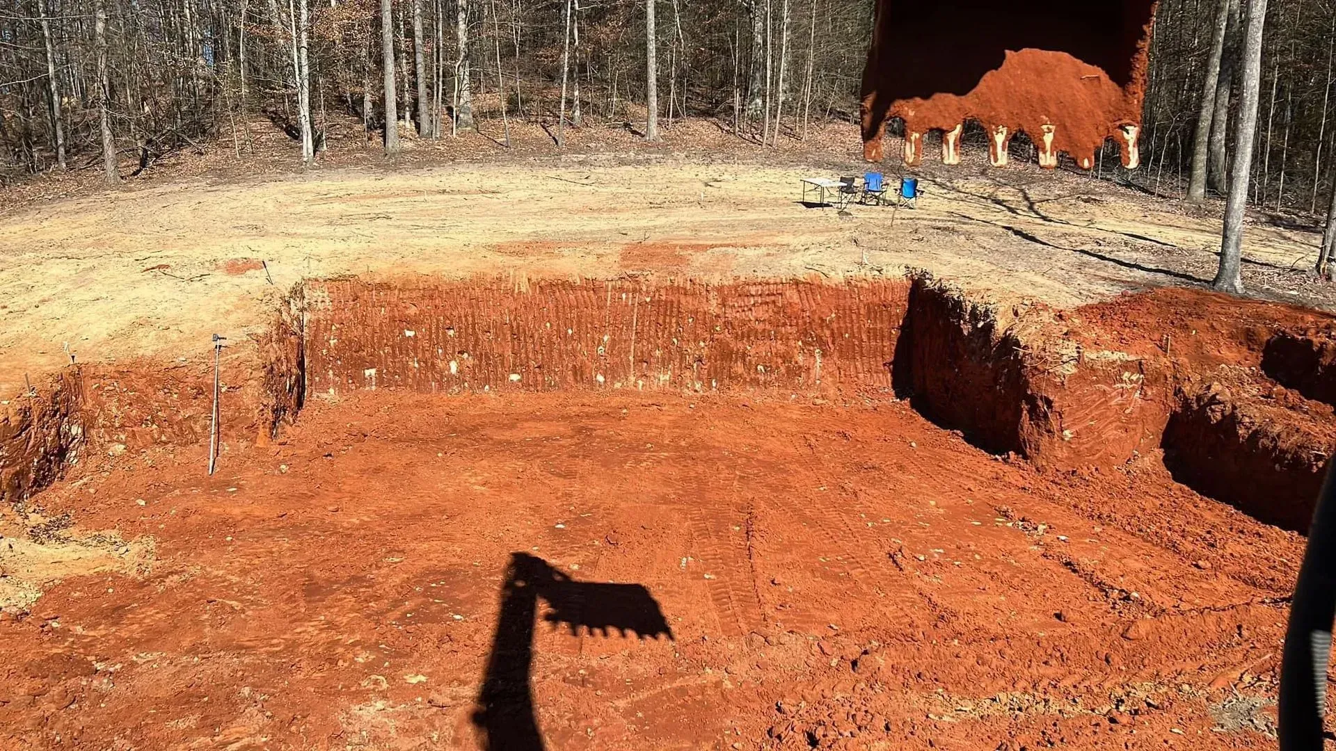 A person is digging a hole in the dirt in a field.