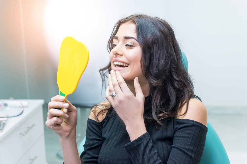 Woman Looking at Her Teeth — Dental Crowns in Newcastle, NSW