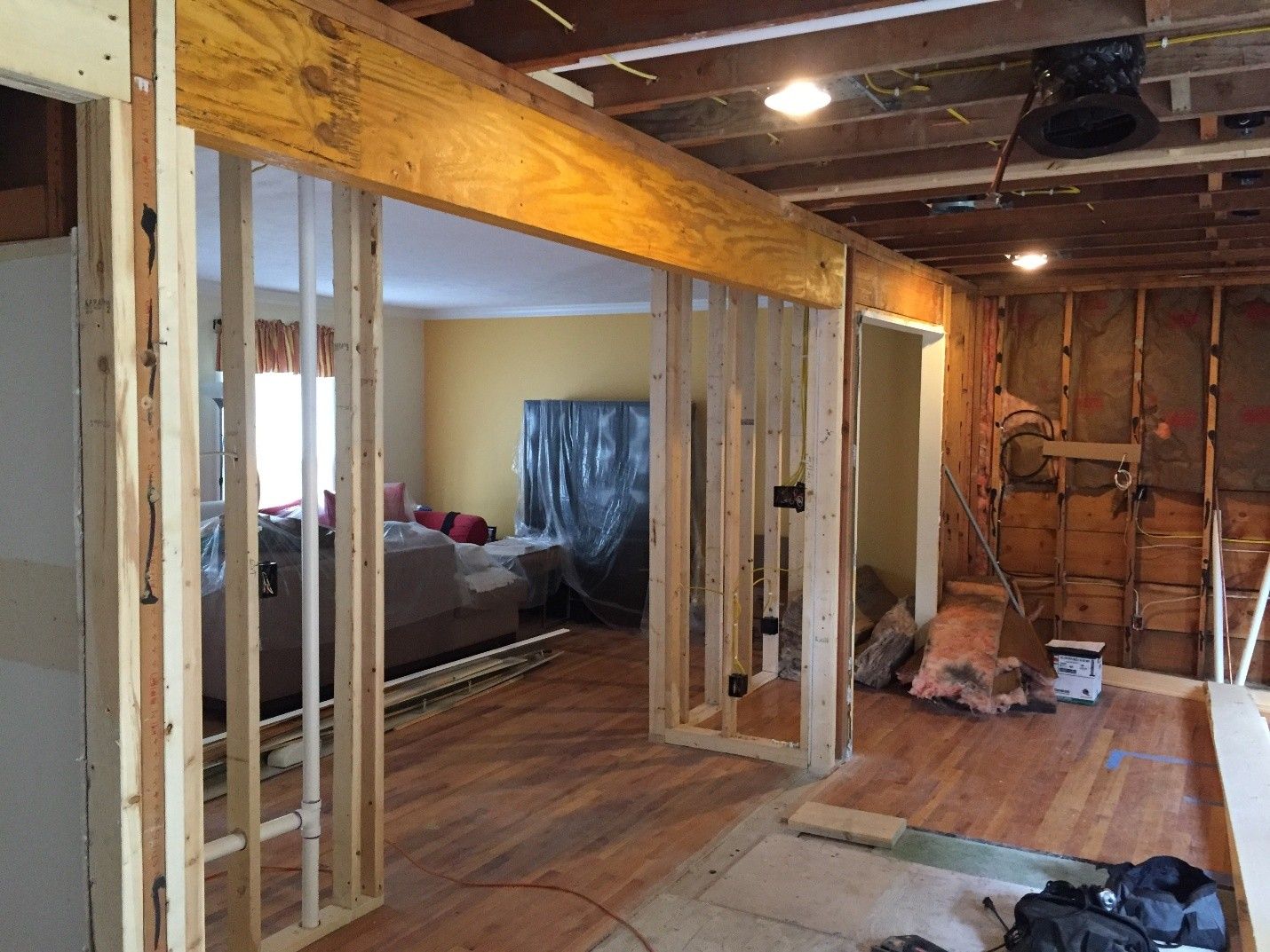Interior view of home undergoing renovation, with exposed framing, doorways, and flooring.