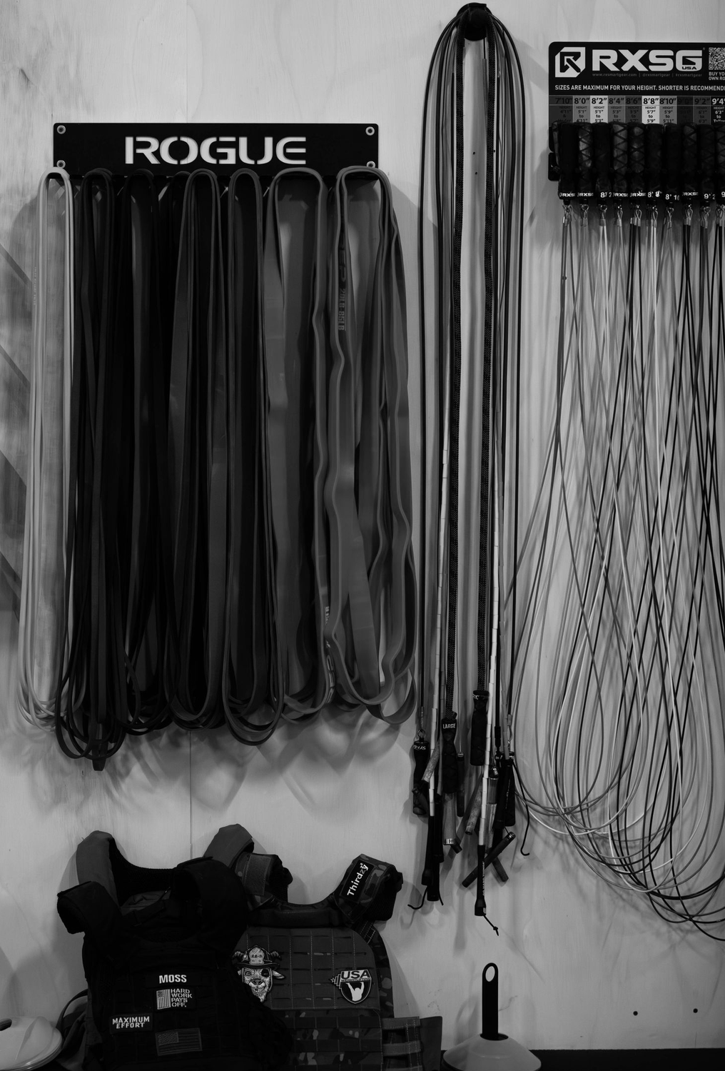 Wrench and strap racks hanging on a wall above boxes in a garage or workshop.