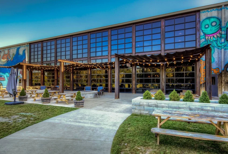 A large building with a lot of windows and a picnic table in front of it.