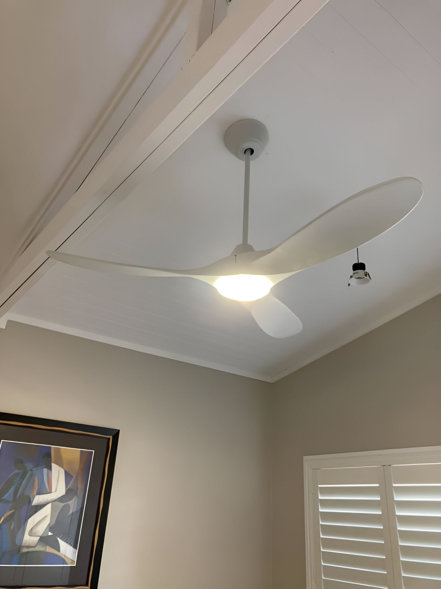 A White Ceiling Fan With Three Curved Blades and a Central Light Fixture — Neave Electrical in Diamond Beach, NSW