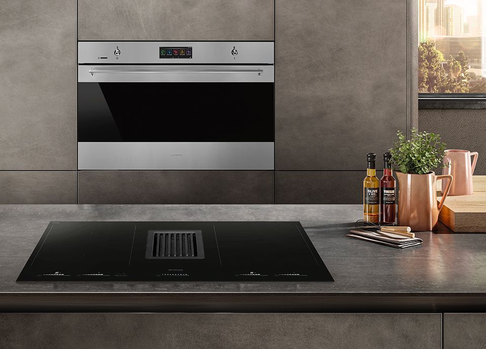 Modern kitchen with black stovetop, built-in oven, and decorative items. — Neave Electrical in Forster, NSW
