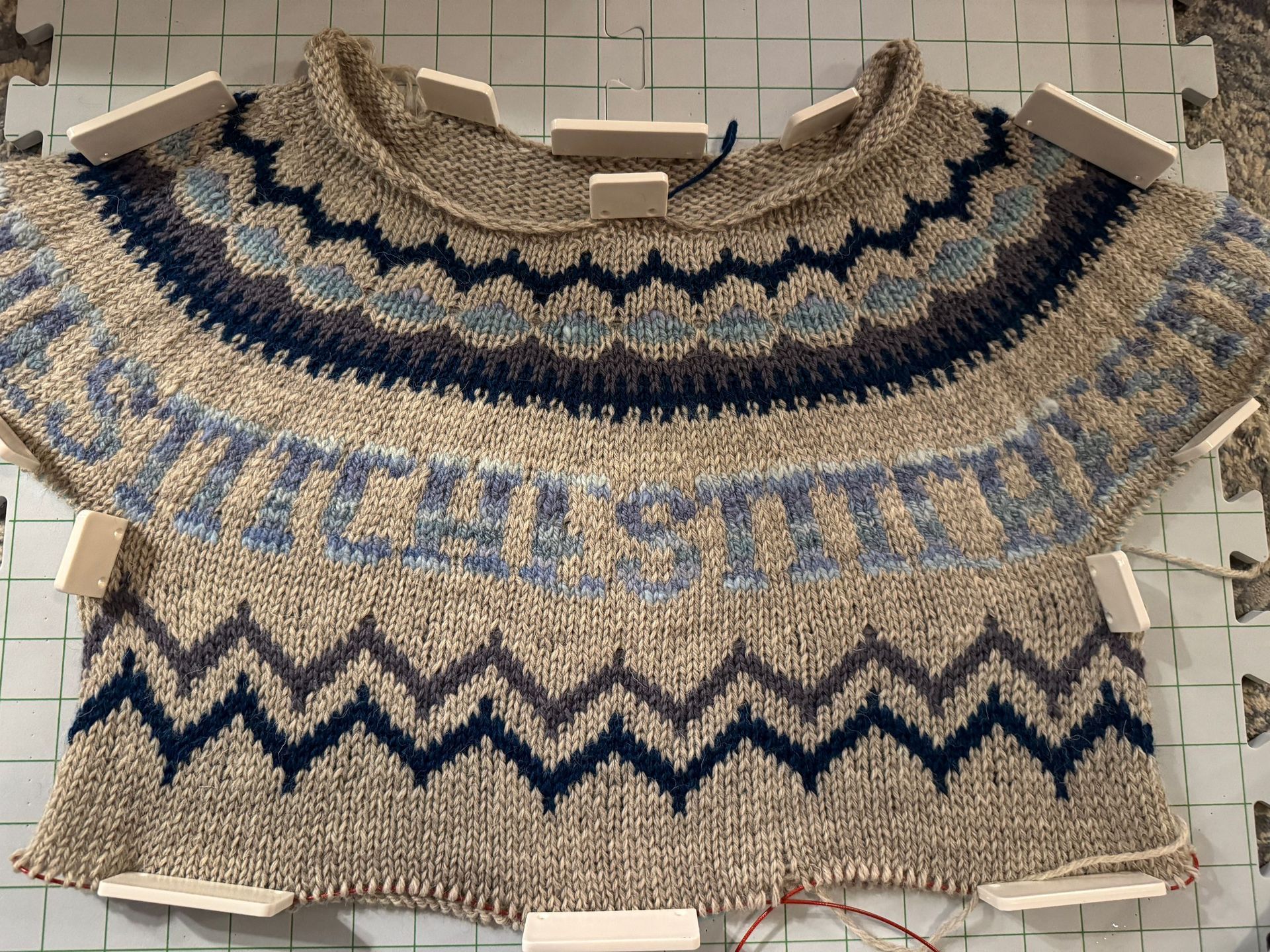 colorwork sweater on blocking mat. 