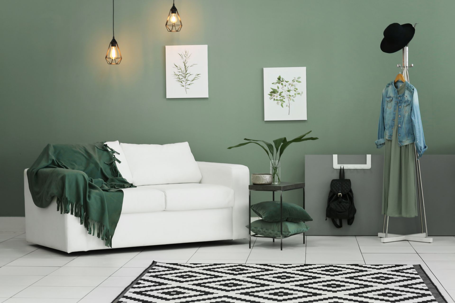 Minimalist living room with green accents, white sofa, wall art, plants, and black-and-white rug.