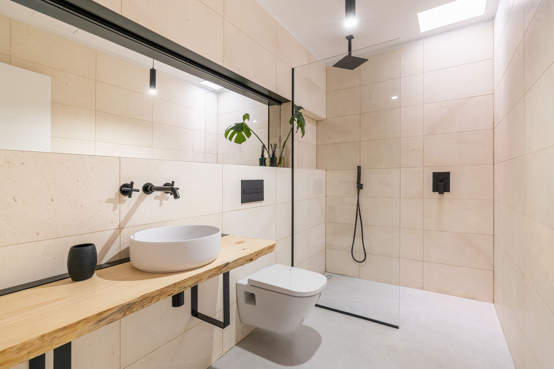 Modern beige bathroom with walk-in shower, floating wood vanity, and wall-mounted toilet