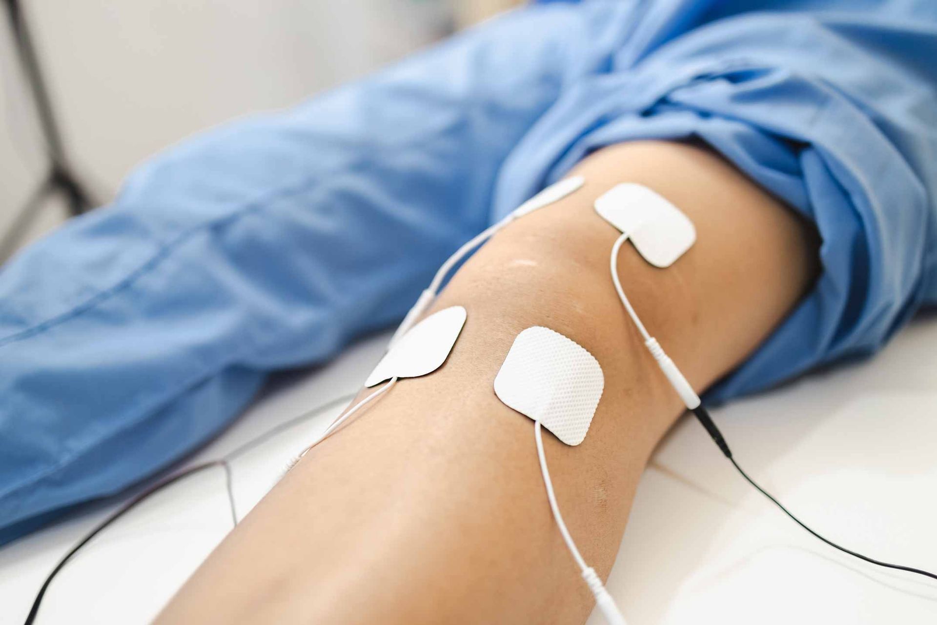 Electrical stimulation pads on a bent arm during physical therapy treatment