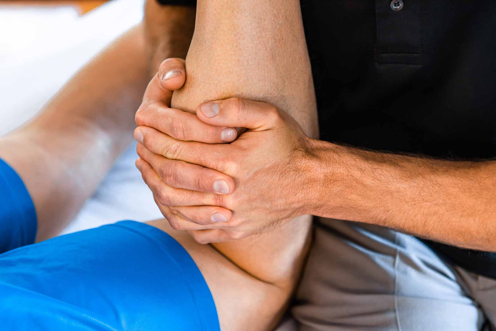Hands holding a person’s bent leg during a physical therapy session