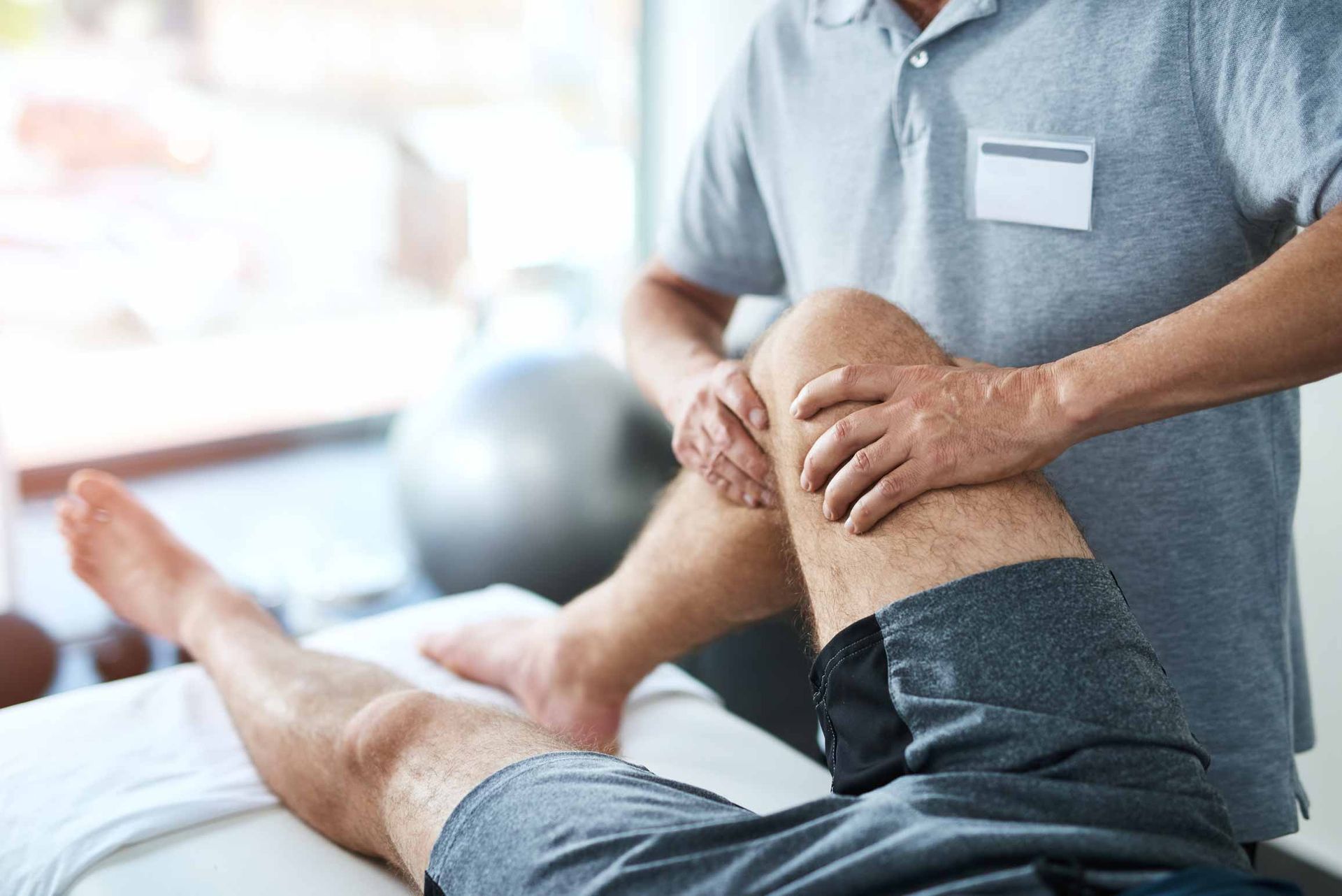 Physical therapist examining a patient’s knee during a rehabilitation session