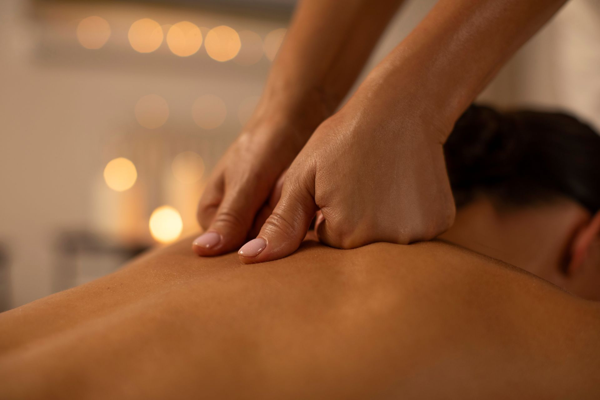 A woman is getting a hot stone massage in a spa.