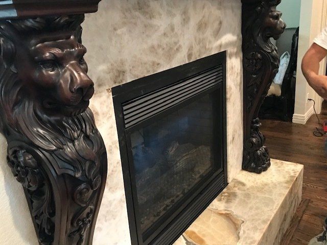 Fireplace with lion-head corbels, black insert, and marble surround. Dark wood floor visible.