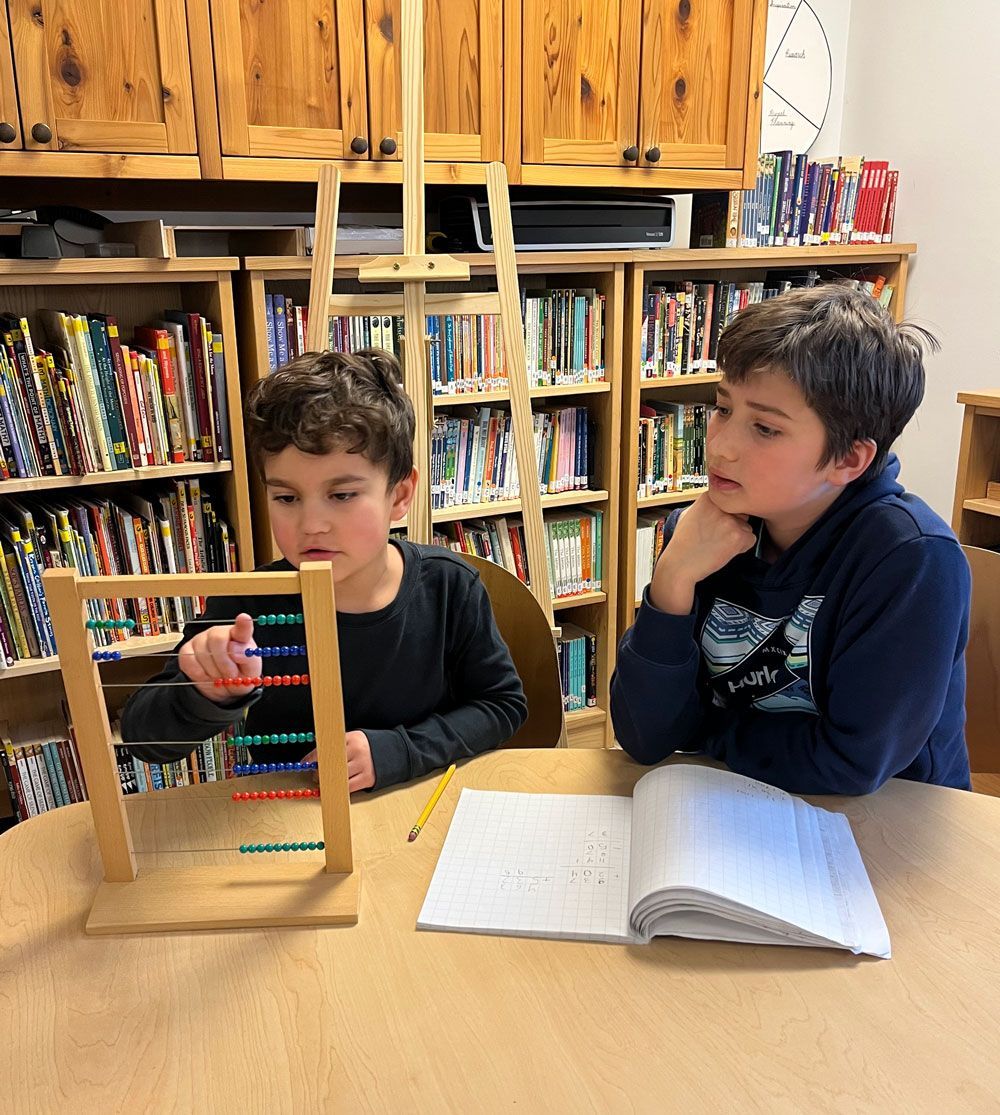 montessori children using abacus and notebook for math practice
