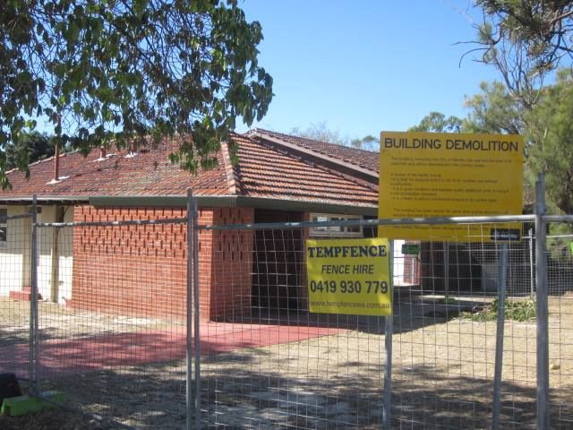 A fence with a building demolition sign on it