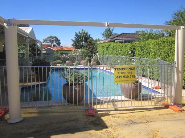 A fence surrounds a swimming pool with a sign that says fence fence