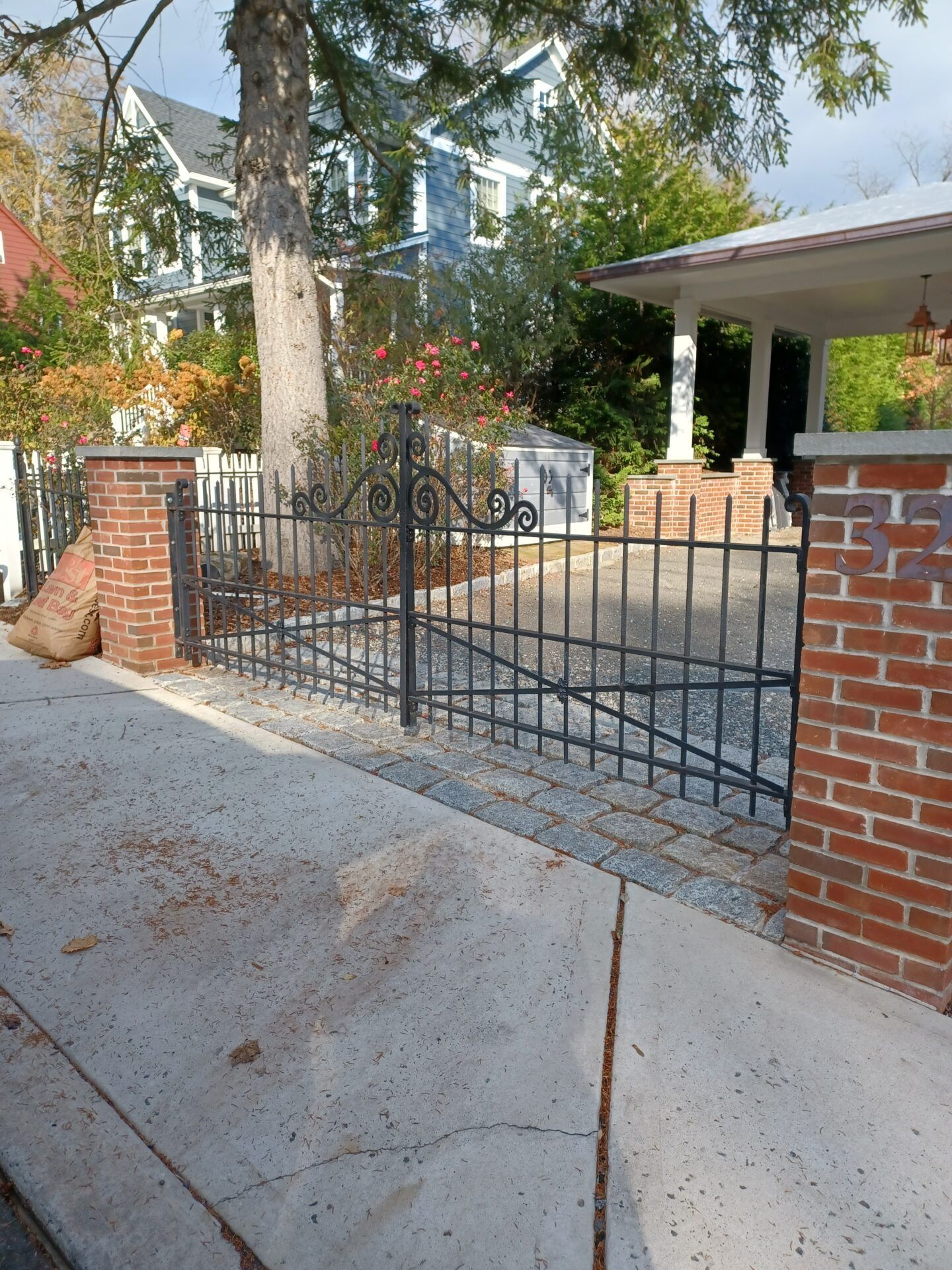 A white vinyl staircase railing attached to stone steps in front of a brick building.