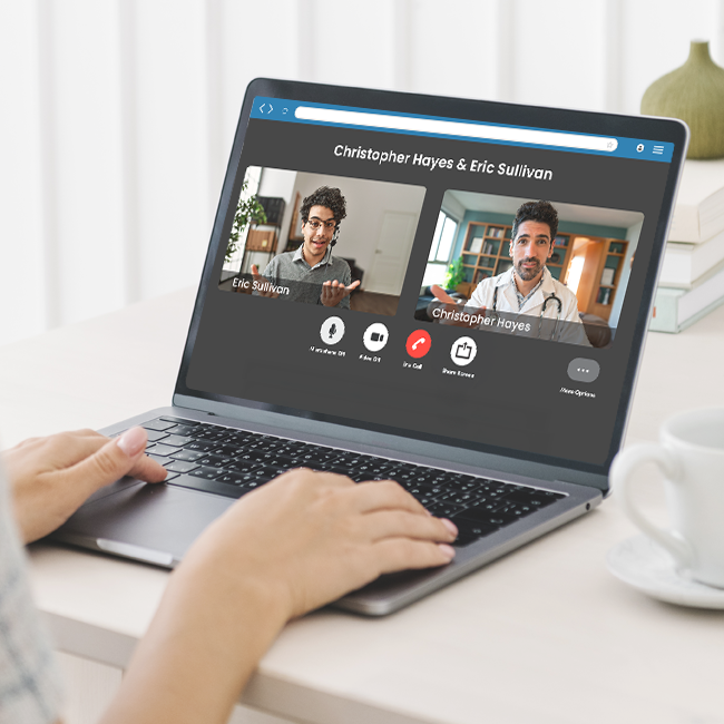 Person using a laptop for a video call with two men.
