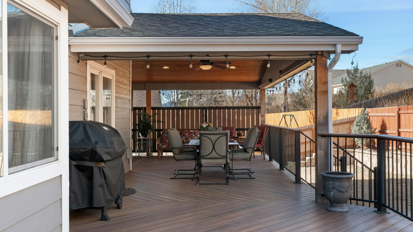 Covered backyard deck with steel railings and patio furniture in Chicago