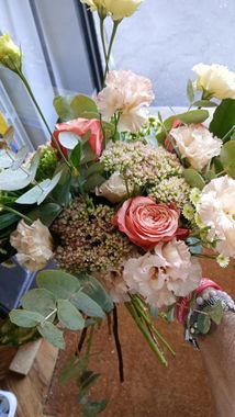 Bouquet di rose bianche con fogliame, steli avvolti in un vaso, sul davanzale di una finestra